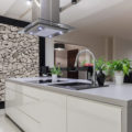 Photo of beautiful white kitchen island with decorative wall